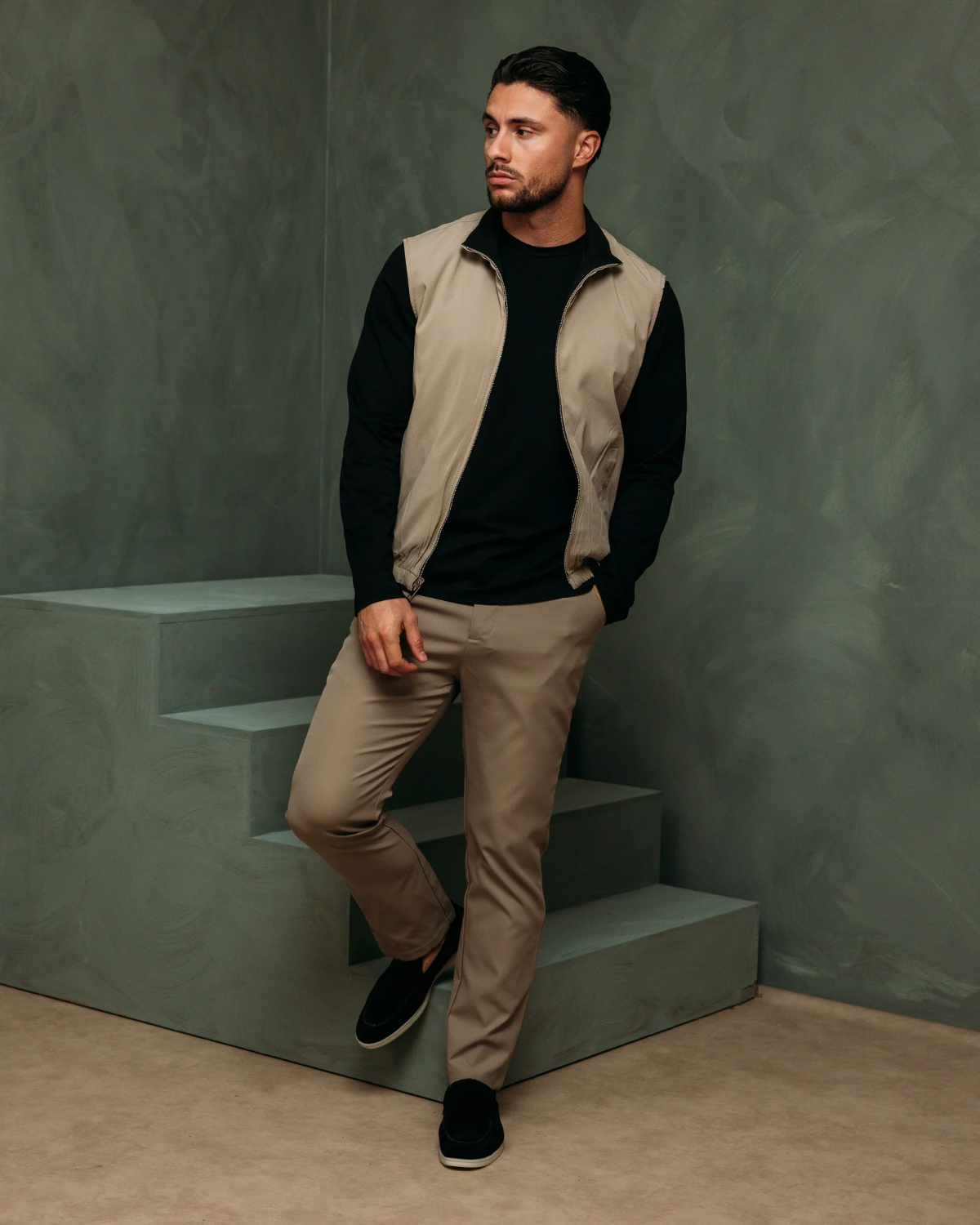 Model op een trap in de Core Bodywarmer Black Beige met de beige kant buiten