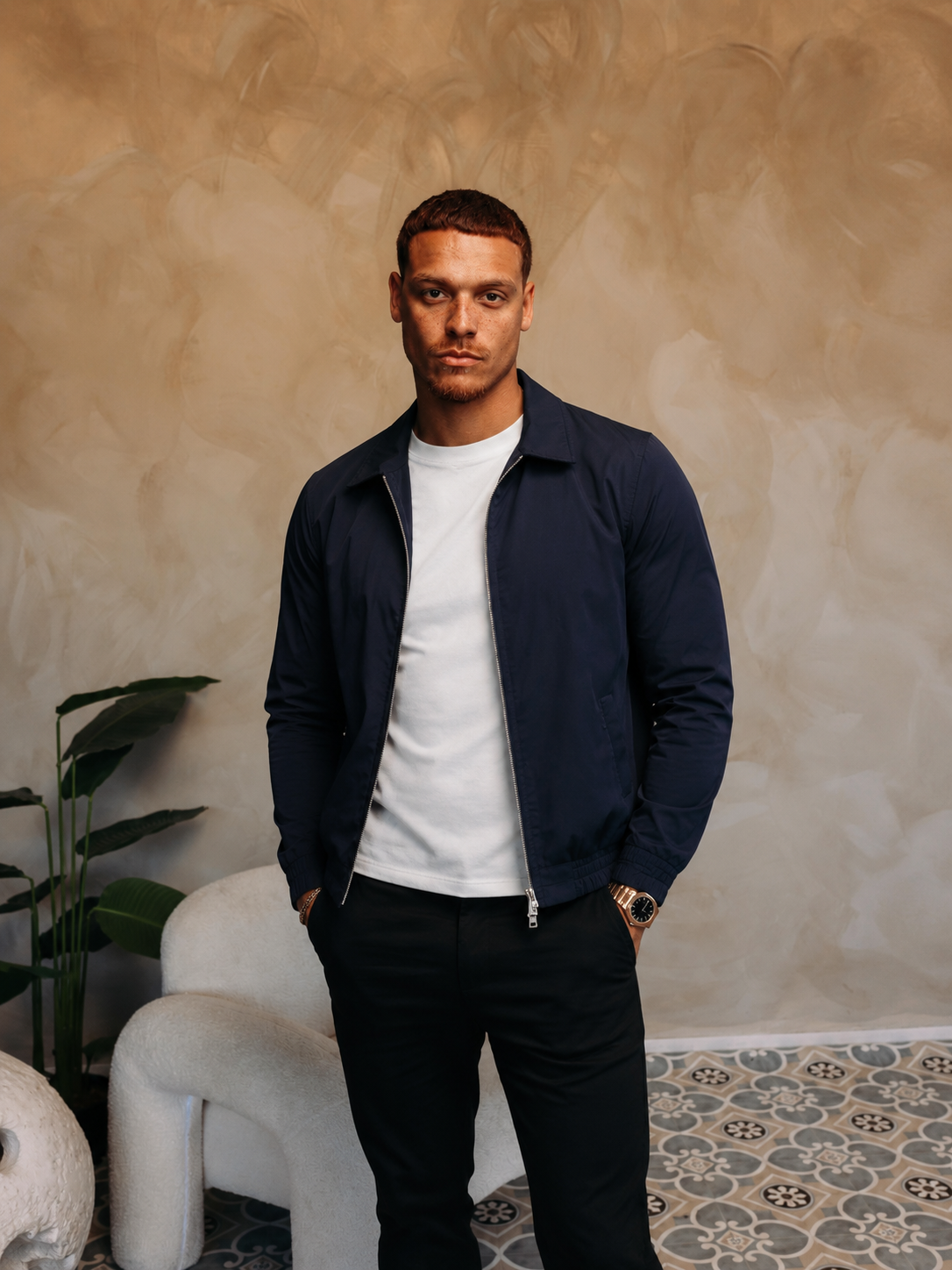 Model in de navy Smart Jacket over een wit T-shirt met een zwarte broek