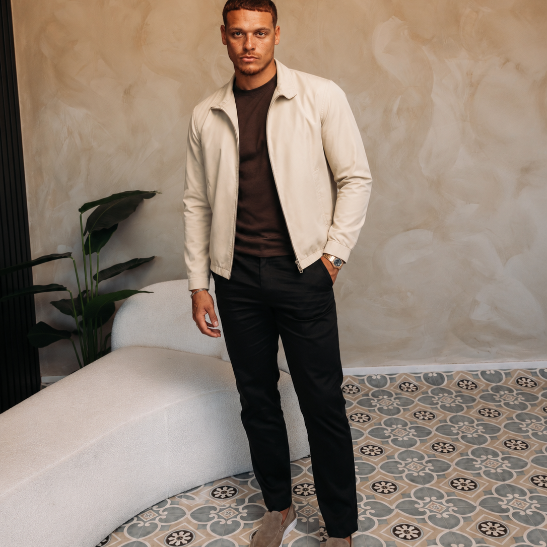 Model in de creme Smart Jacket over een bruin T-shirt met een zwarte broek