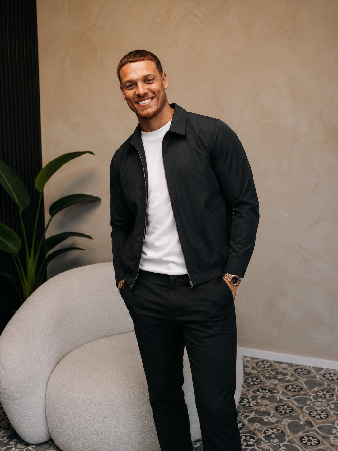 Lachend model in de zwarte Smart Jacket over een wit T-shirt