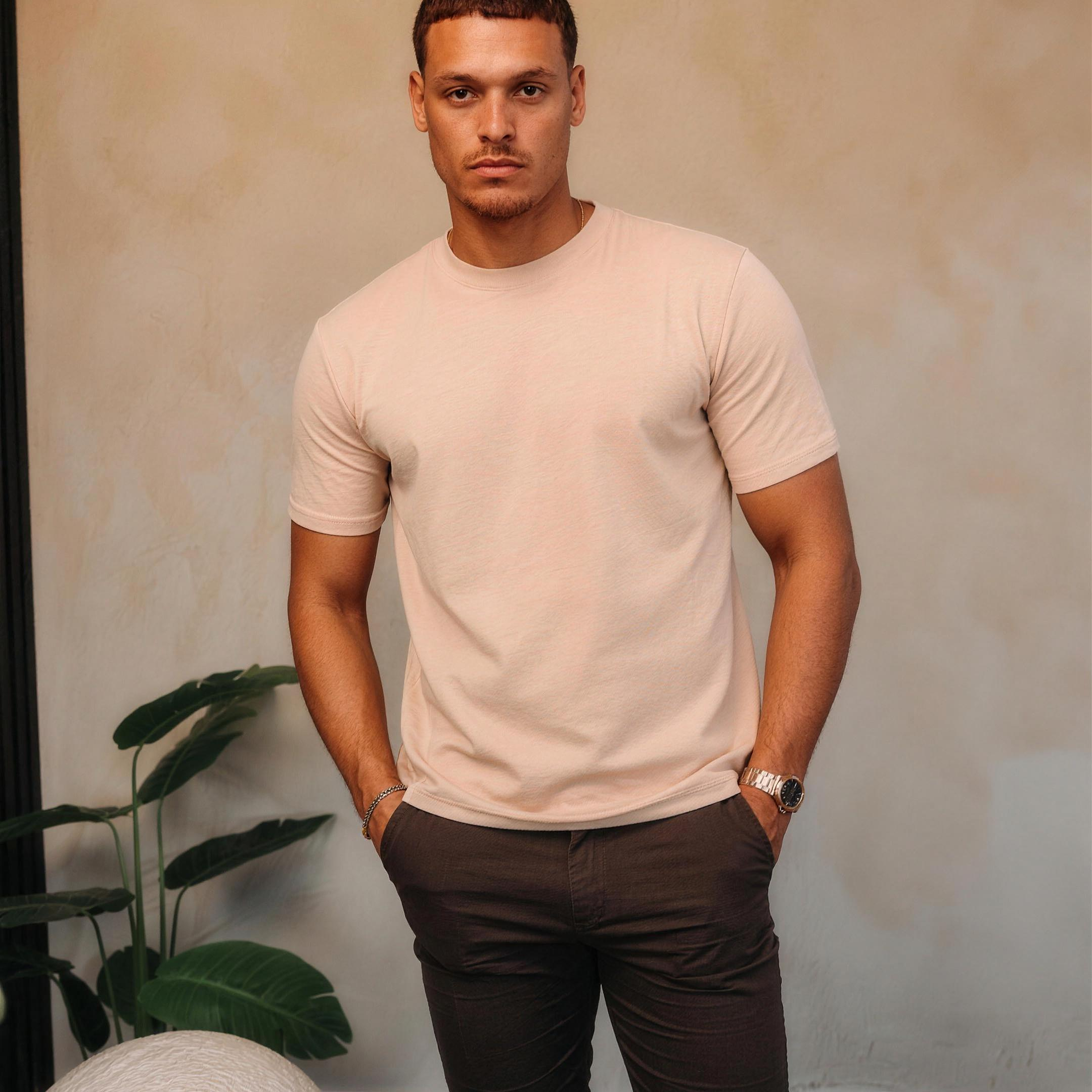 Model in het beige Gloss Essential Shirt met een bruine broek