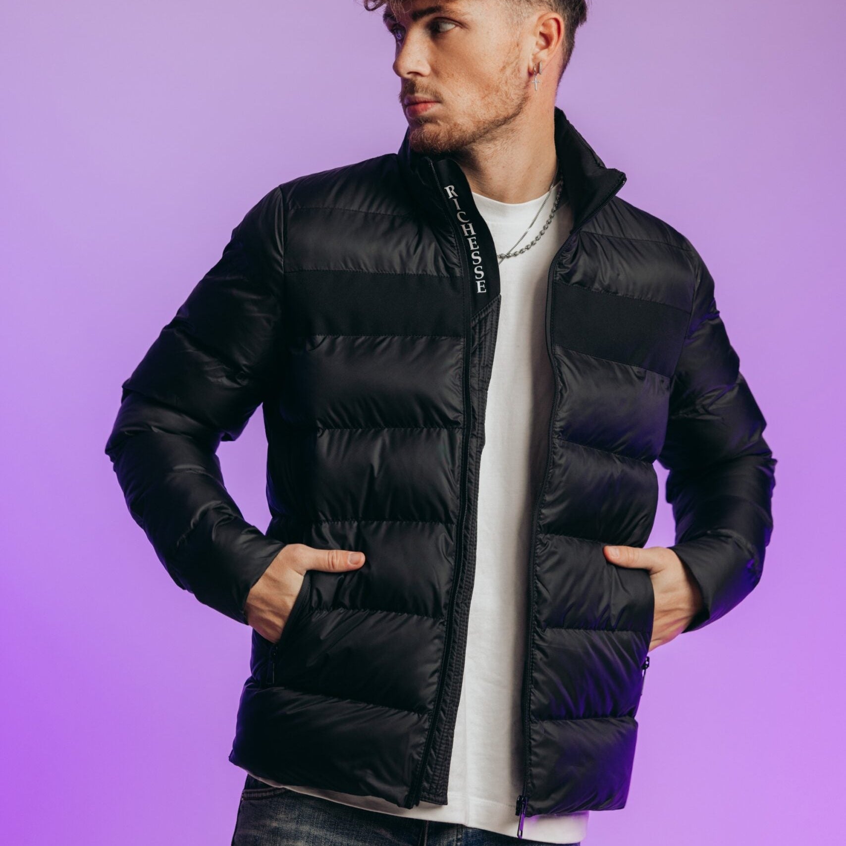 Model in de zwarte Hastings Puffer Jacket met wit shirt en jeans