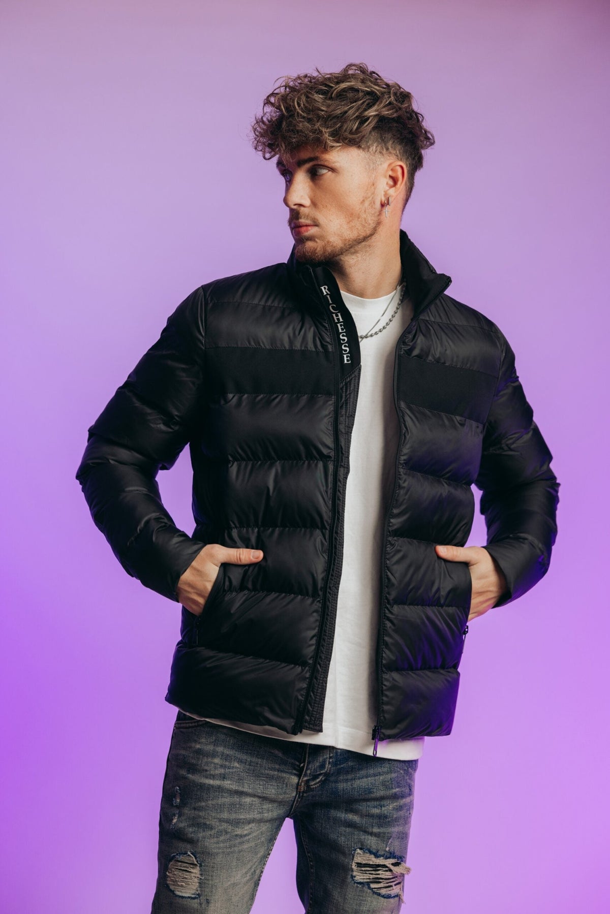 Model in de zwarte Hastings Puffer Jacket met wit shirt en jeans